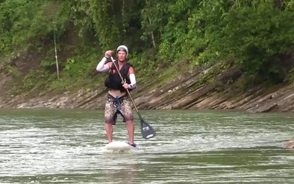 Josh Galt stand-up paddling a jungle river